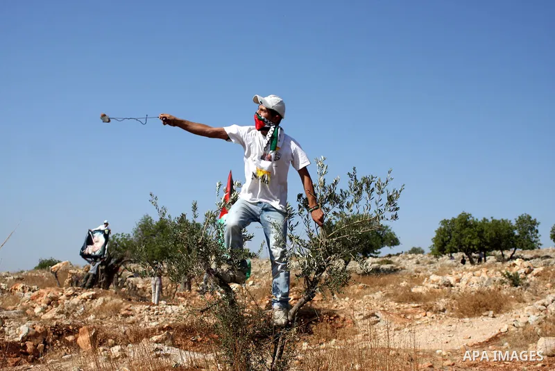 A Palestinian protester hurls stones at Israeli soldiers during clashes in the West Bank village of Nilin, near the Palestinians city of Ramallah,on Nov. 5, 2010. Clashes erupted during the weekly demonstrations, which a...