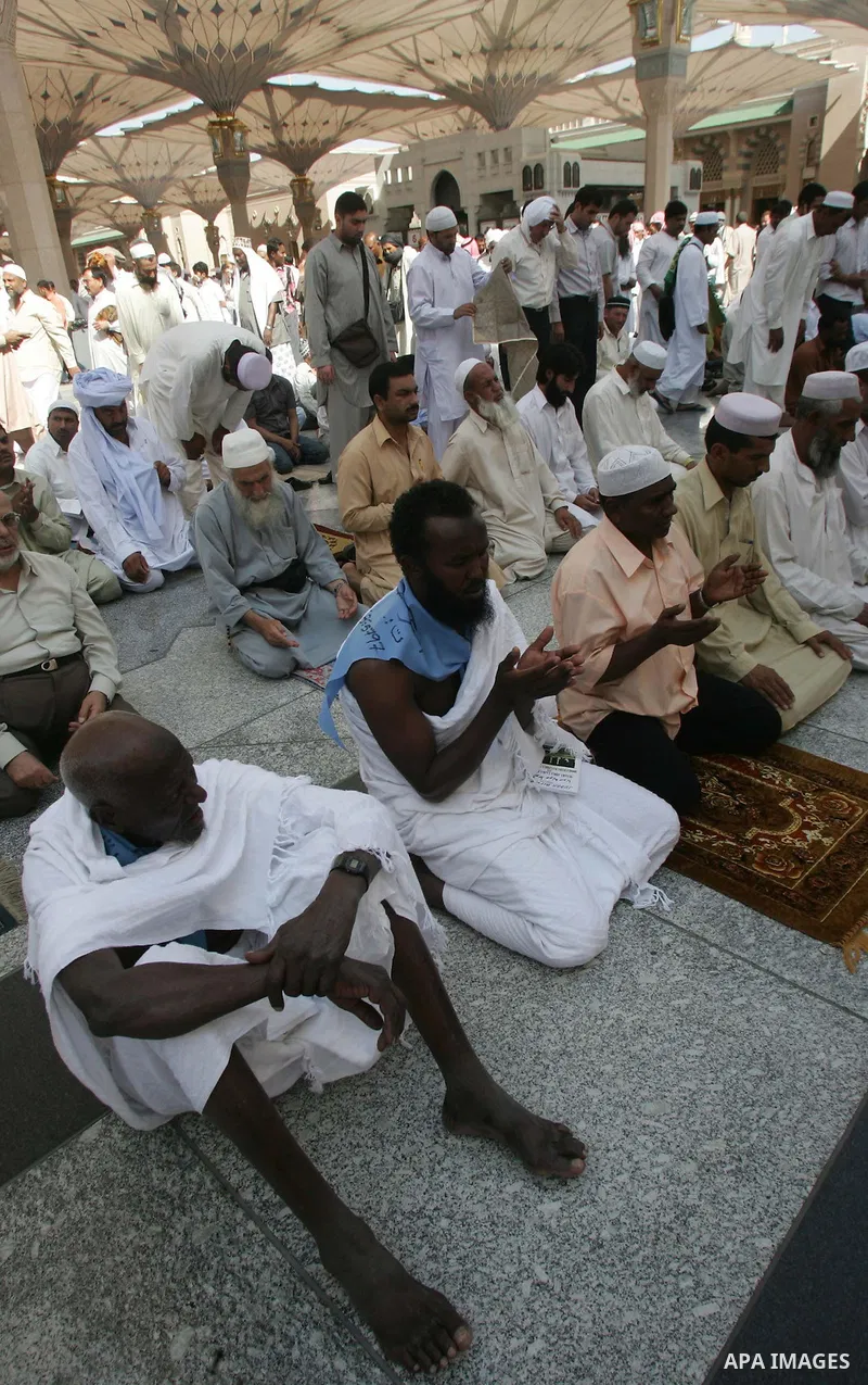 Muslim pilgrims attend Friday prayers outside the Prophet Mohammed Mosque in the Saudi holy city of Medina on November 5, 2010. More than three million Muslims are expected to converge on the holy cities of Mecca and Med...