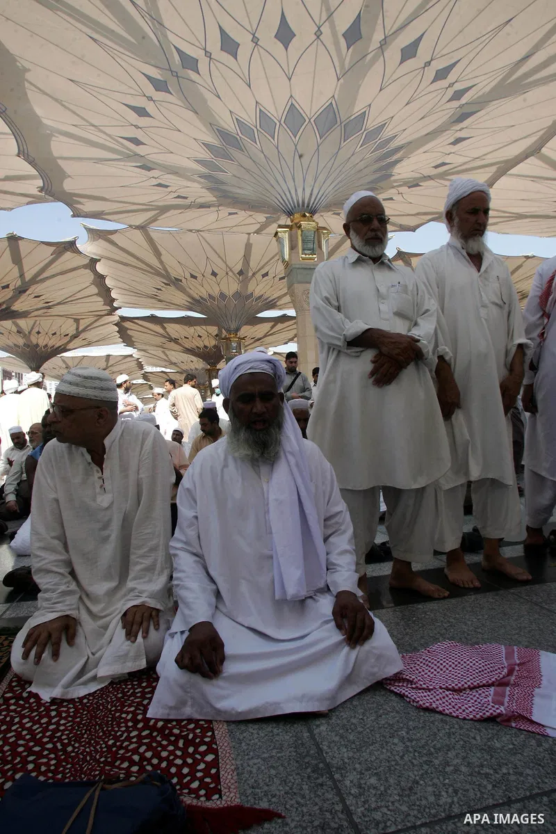Muslim pilgrims attend Friday prayers outside the Prophet Mohammed Mosque in the Saudi holy city of Medina on November 5, 2010. More than three million Muslims are expected to converge on the holy cities of Mecca and Med...