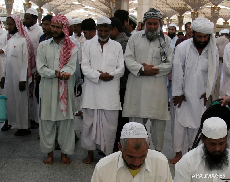 Muslim pilgrims attend Friday prayers outside the Prophet Mohammed Mosque in the Saudi holy city of Medina on November 5, 2010. More than three million Muslims are expected to converge on the holy cities of Mecca and Med...