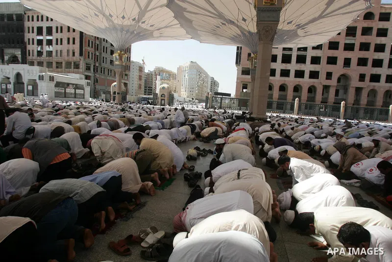 Muslim pilgrims attend Friday prayers outside the Prophet Mohammed Mosque in the Saudi holy city of Medina on November 5, 2010. More than three million Muslims are expected to converge on the holy cities of Mecca and Med...
