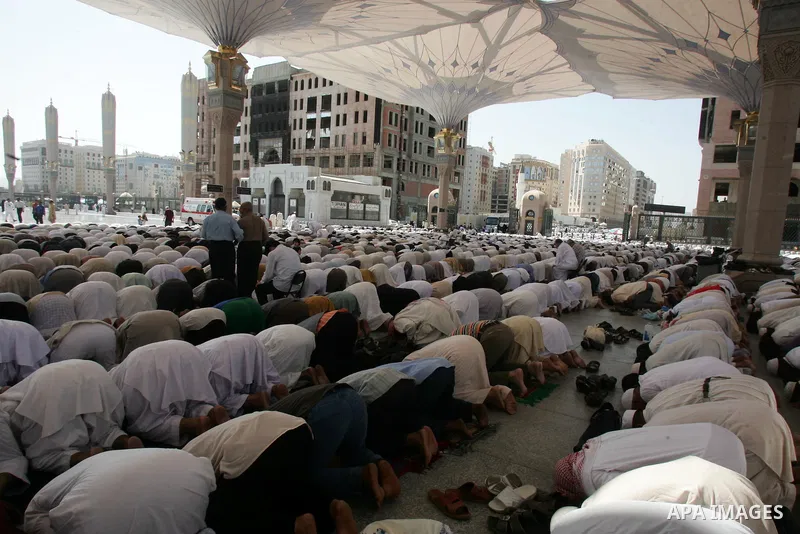 Muslim pilgrims attend Friday prayers outside the Prophet Mohammed Mosque in the Saudi holy city of Medina on November 5, 2010. More than three million Muslims are expected to converge on the holy cities of Mecca and Med...
