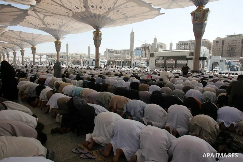 Muslim pilgrims attend Friday prayers outside the Prophet Mohammed Mosque in the Saudi holy city of Medina on November 5, 2010. More than three million Muslims are expected to converge on the holy cities of Mecca and Med...