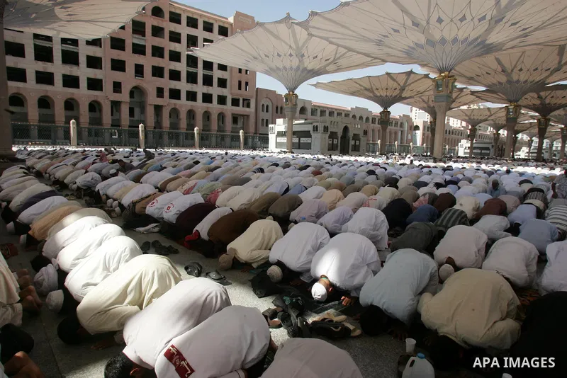 Muslim pilgrims attend Friday prayers outside the Prophet Mohammed Mosque in the Saudi holy city of Medina on November 5, 2010. More than three million Muslims are expected to converge on the holy cities of Mecca and Med...