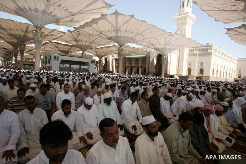 Muslim pilgrims attend Friday prayers outside the Prophet Mohammed Mosque in the Saudi holy city of Medina on November 5, 2010. More than three million Muslims are expected to converge on the holy cities of Mecca and Med...