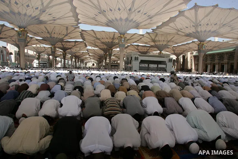 Muslim pilgrims attend Friday prayers outside the Prophet Mohammed Mosque in the Saudi holy city of Medina on November 5, 2010. More than three million Muslims are expected to converge on the holy cities of Mecca and Med...