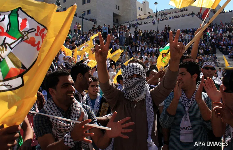 Palestinian students supporters of the Fatah movement wave with the party flag during the celebration of the student council elections at al-Najah University in the West Bank town of Nablus, Monday, Nov. 8, 2010. Photo b...