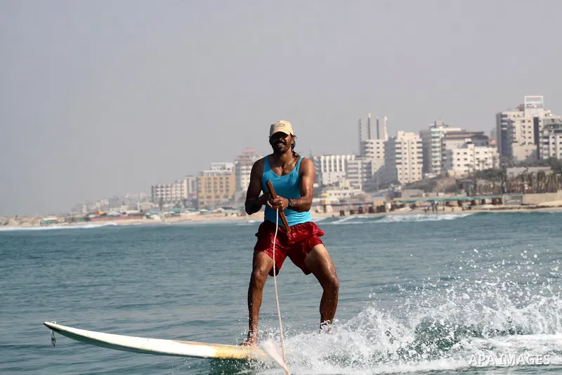 A Palestinian man teach his daughters to ride the waves sport in Gaza city beach on Nov 12,2010.. Photo by Mohammed Asad