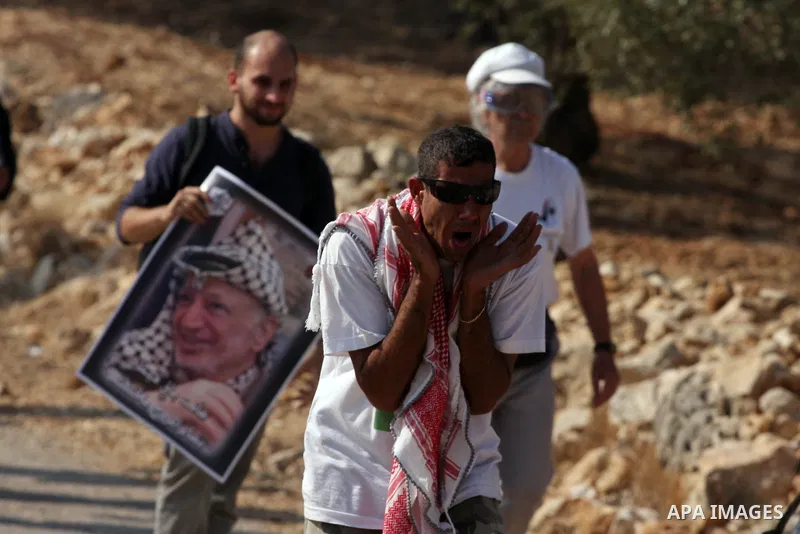 Palestinian and foreign peace activists protest against Israel's separation barrier as masked Palestinian stones throwers clash with Israeli soldiers in the West Bank village of Bilin, near Ramallah, on November 12, 2010...