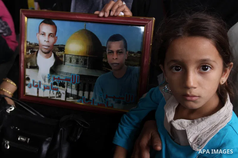 Palestinian women and children hold pictures of jailed relatives during a protest calling for the release of Palestinian prisoners from Israeli jails at the Red Cross office in Gaza City on November 15,2010 . Photo by Mo...