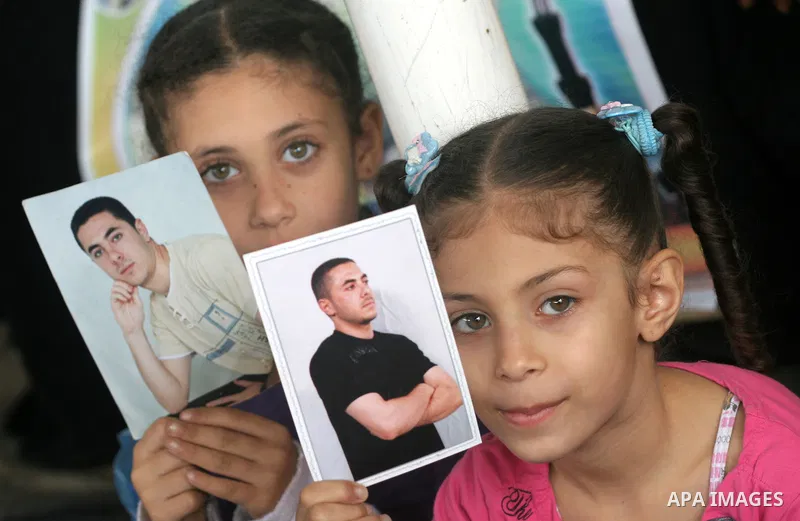 Palestinian women and children hold pictures of jailed relatives during a protest calling for the release of Palestinian prisoners from Israeli jails at the Red Cross office in Gaza City on November 15,2010 . Photo by Mo...