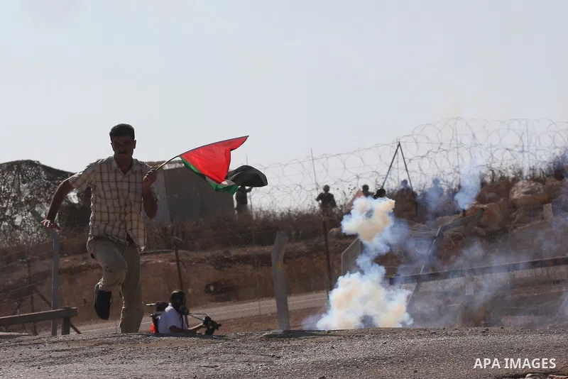 Palestinians run for cover from tear gas canisters fired by Israeli soldiers during a demonstration against Israel's separation barrier in the West Bank village of Bilin near the West Bank city of Ramallah Nov. 18, 2010....