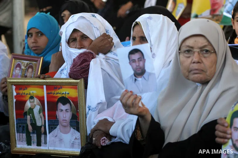 Palestinian women and children hold pictures of jailed relatives during a protest calling for the release of Palestinian prisoners from Israeli jails at the Red Cross office in Gaza City on Nov. 22,2010 . Photo by Mohamm...