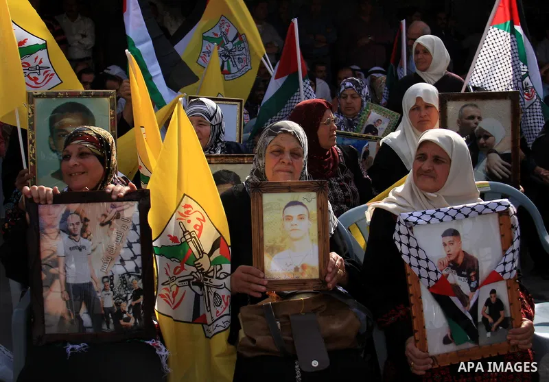 Palestinians sign on a long scroll of solidarity message with prisoners held in Israeli jails during a rally calling for their release in the West Bank City of Tulkarem on Nov. 28, 2010. Thousands of Palestinians took pa...