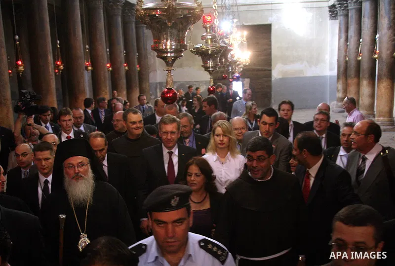 German President Christian Wulff (C) listens to an explanation as he visits the Church of the Nativity, believed to be by Christians the birthplace of Jesus Christ, in the West Bank city of Bethlehem on November 30, 2010...