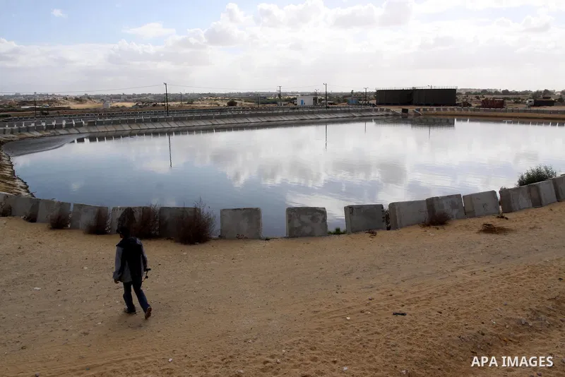 Palestinians stand near waste water treatment plant of Rafah which was upgraded by the International Committee of the Red Cross (ICRC) in the southern Gaza Strip on Dec. 6, 2009. The International Committee of the Red Cr...