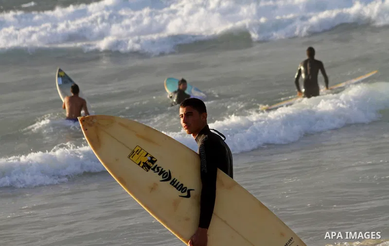 Palestinian youths practise their sport ( riding the waves ) during sunset in Gaza city beach on Dec. 6,2010. Photo by Ashraf Amra