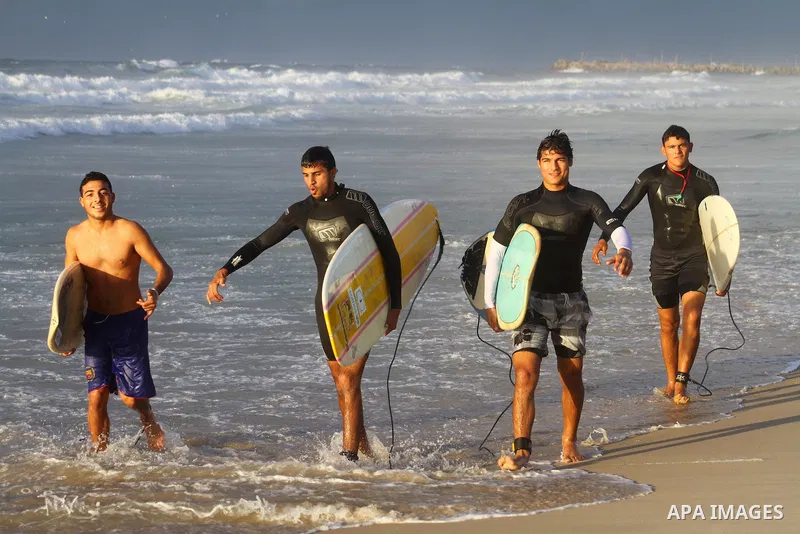 Palestinian youths practise their sport ( riding the waves ) during sunset in Gaza city beach on Dec. 6,2010. Photo by Ashraf Amra