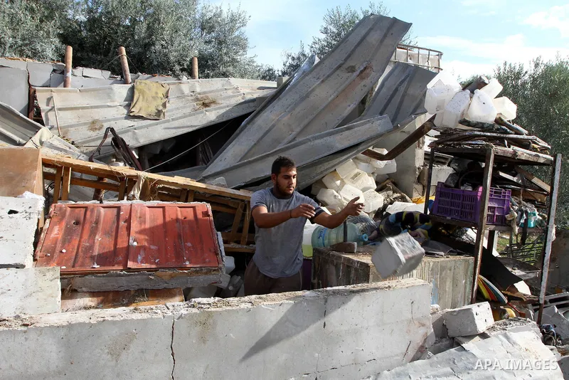 A Palestinian man removed the rubble of his destroyed house after it was damaged when Israeli air force bombed a nearby Hamas facility in Gaza City on December 9, 2010 along with 3 other sites in the territory after Pale...