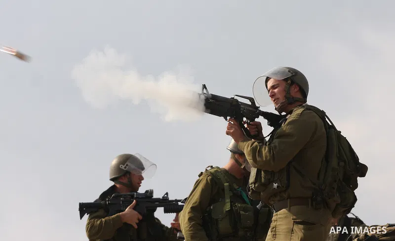 Israeli soldiers fire tear gas during a demonstration against the construction of the Israeli controversial separation barrier in the West Bank village of Bilin near Ramallah on, Dec. 10, 2010. Photo by Issam Rimawi