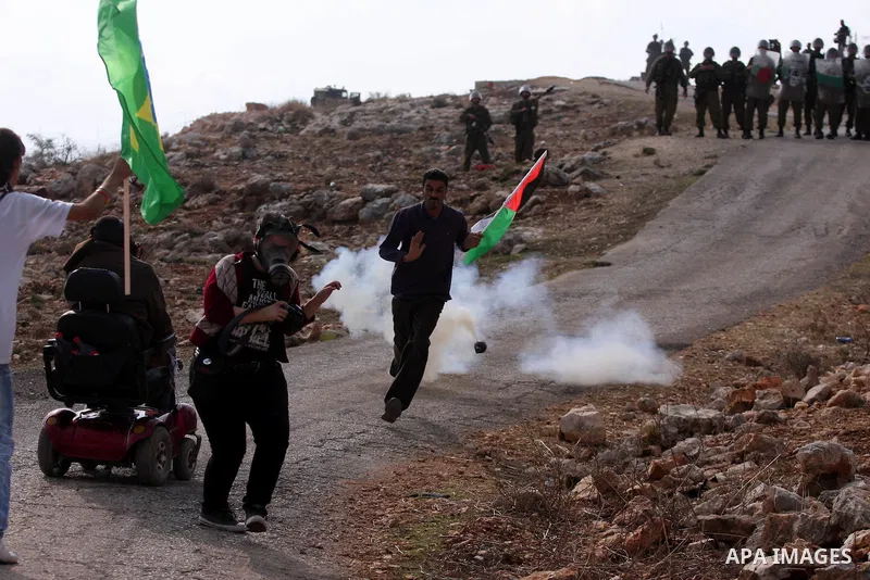 Israeli soldiers fire tear gas during a demonstration against the construction of the Israeli controversial separation barrier in the West Bank village of Bilin near Ramallah on, Dec. 10, 2010. Photo by Issam Rimawi