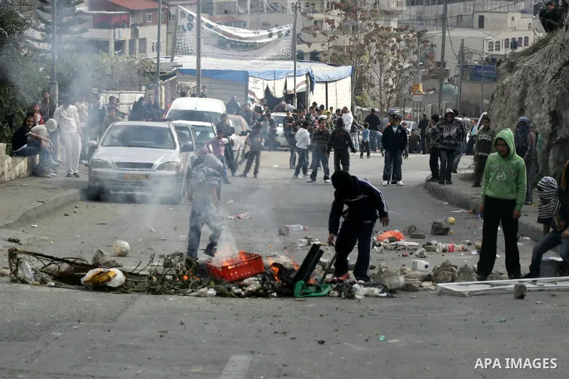Palestinian youths hurl stones at Israeli soldiers during the clashes in the east Jerusalem neighborhood of Silwan after Friday prayers on Dec. 10, 2010. Photo by Mahfouz Abu Turk