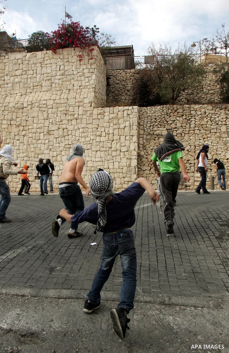 Palestinian youths hurl stones at Israeli soldiers during the clashes in the east Jerusalem neighborhood of Silwan after Friday prayers on Dec. 10, 2010. Photo by Mahfouz Abu Turk