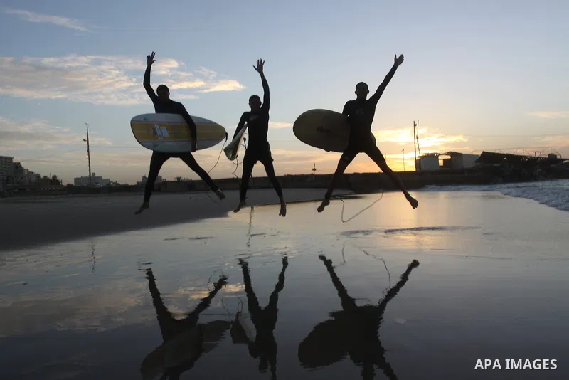 Palestinian youths carry their boards on the beach as they prepare to surf in Gaza City on December 16, 2010. Photo by Mohammed Asad