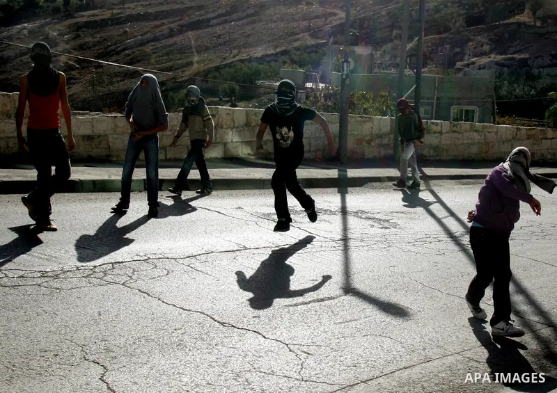 Palestinian youths throw stones at Israeli security forces during a protest after the weekly Friday prayers on December 17, 2010 in the Arab east Jerusalem neighbourhood of Silwan against Jewish settlement in Palestinian...