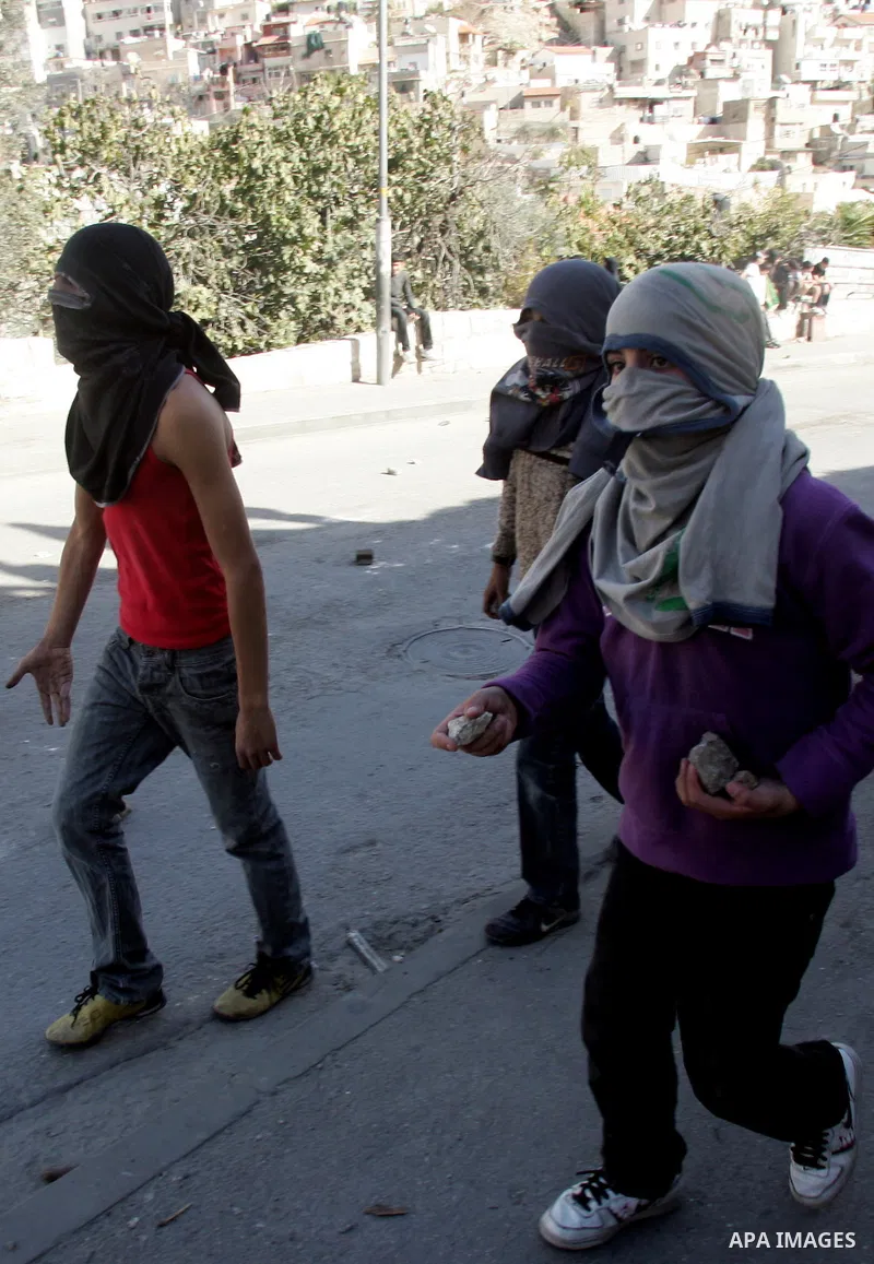 Palestinian youths throw stones at Israeli security forces during a protest after the weekly Friday prayers on December 17, 2010 in the Arab east Jerusalem neighbourhood of Silwan against Jewish settlement in Palestinian...