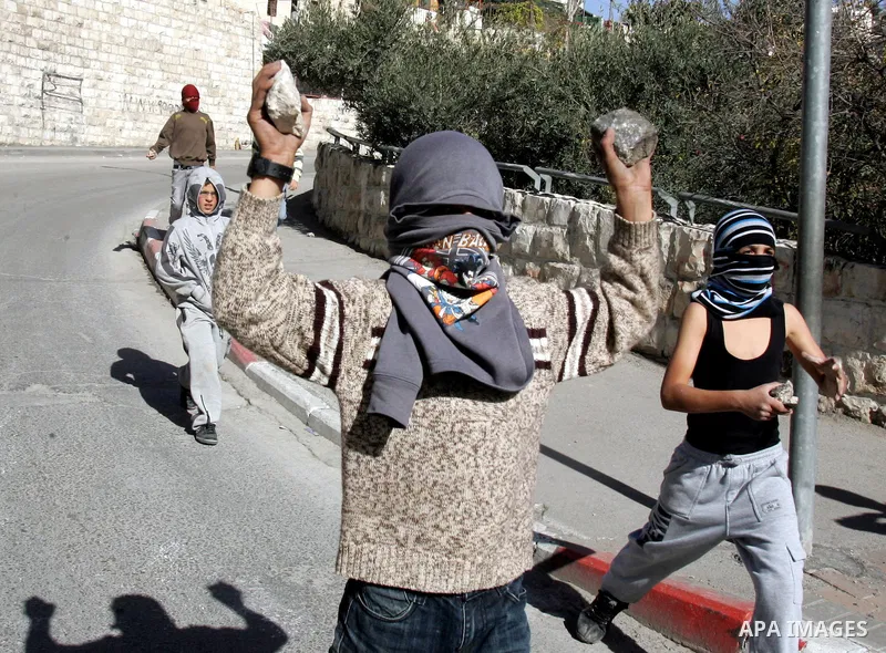 Palestinian youths throw stones at Israeli security forces during a protest after the weekly Friday prayers on December 17, 2010 in the Arab east Jerusalem neighbourhood of Silwan against Jewish settlement in Palestinian...