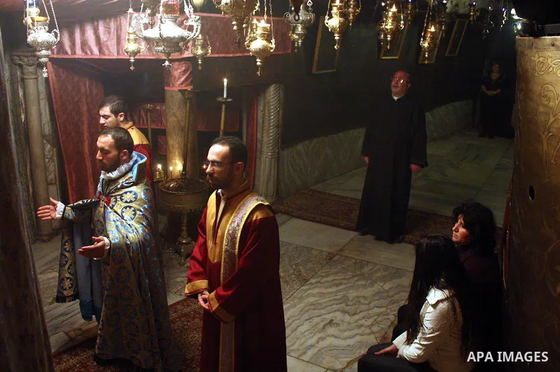 An Armenian Orthodox priest performs a mass in the 'Grotto,' or cave in the Church of the Nativity in the Church of the Nativity in the biblical West Bank city of Bethlehem on December 19, 2010 as part of the preparation...