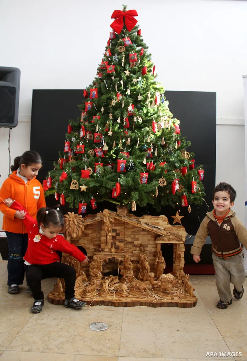 Palestinian christian boys take part during the Christmas tree Exhibiting and Bazaar inside the Center building in Manger square, in the biblical West Bank town of Bethlehem, Dec.19, 2010. Photo by Najeh Hashlamoun