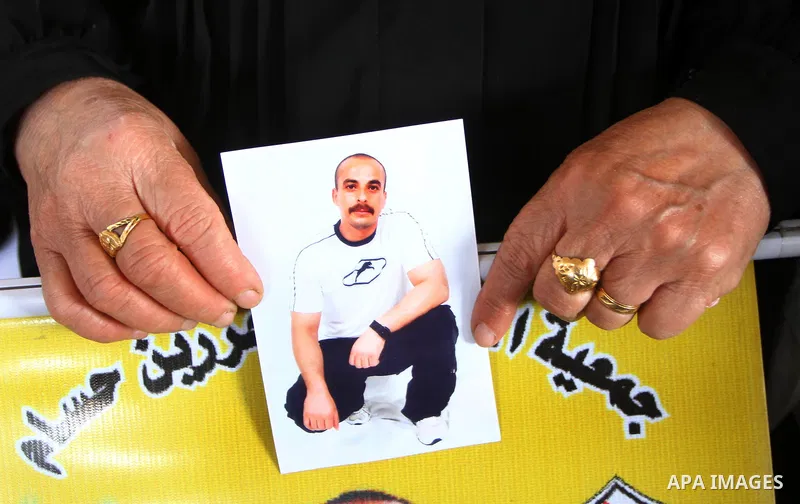 A Palestinian woman holds a picture of his jailed relative during a weekly protest demanding to liberate prisoners from Israeli jails at the Red Cross headquarters in Gaza City, on Dec. 20, 2010. Photo by Ashraf Amra