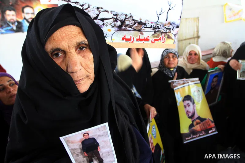 A Palestinian woman holds a picture of his jailed relative during a weekly protest demanding to liberate prisoners from Israeli jails at the Red Cross headquarters in Gaza City, on Dec. 20, 2010. Photo by Ashraf Amra