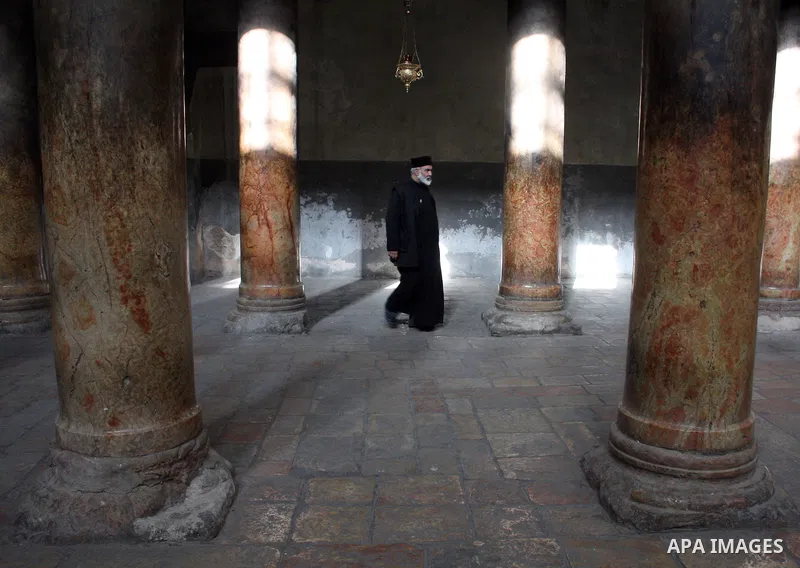 A Christian man walks through a shaft of light entering the Church of the Nativity in the West Bank town of Bethlehem on December 22, 2010. The light passes through an Orthodox Christian section of the church in the cent...