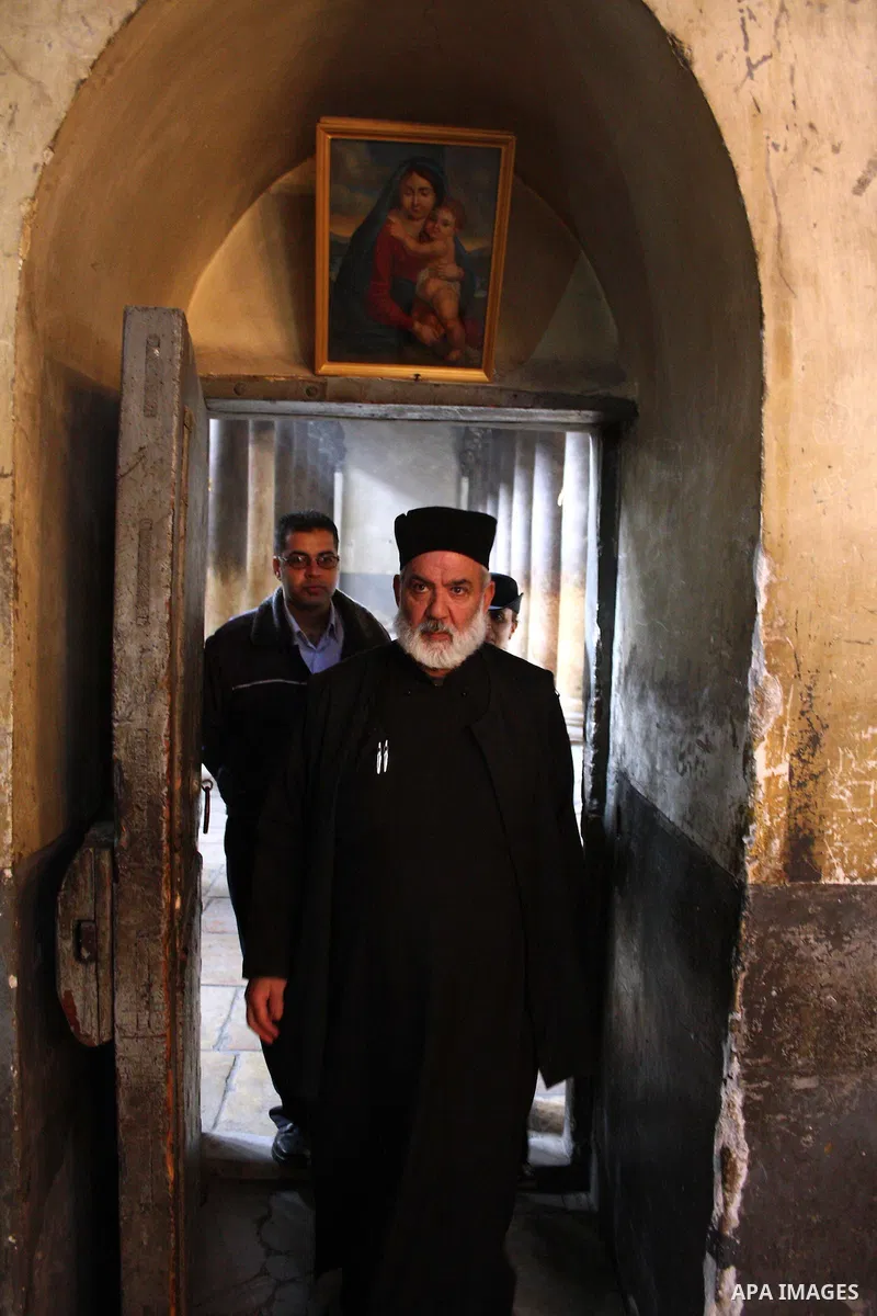 Members of the Palestinian police stand guard through a shaft of light entering the Church of the Nativity in the West Bank town of Bethlehem on December 22, 2010. The light passes through an Orthodox Christian section o...