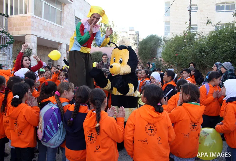 Palestinian Prime Minister Salam Fayyad (not seen) takes part during a Christmas parade in the West Bank city of Bethlehem on 23 December 2010. Scores of Christian pilgrims are preparing to gather in the traditional birt...