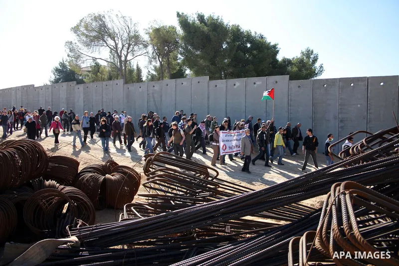 Palestinian and foreign demonstrators take part in a protest against Israel's controversial separation barrier in the West Bank village of Walajah near the biblical town of Bethlehem on 24 December 2010.. Photo by Najeh...