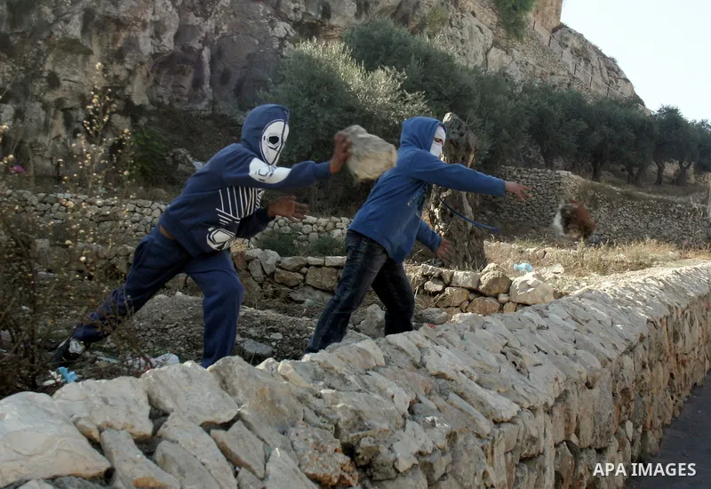 Palestinian youths throw stones towards Israeli soldiers during clashes in the Arab east Jerusalem neighbourhood of Silwan against Jewish settlement activity in the Palestinian districts of the holy city on December 24,...