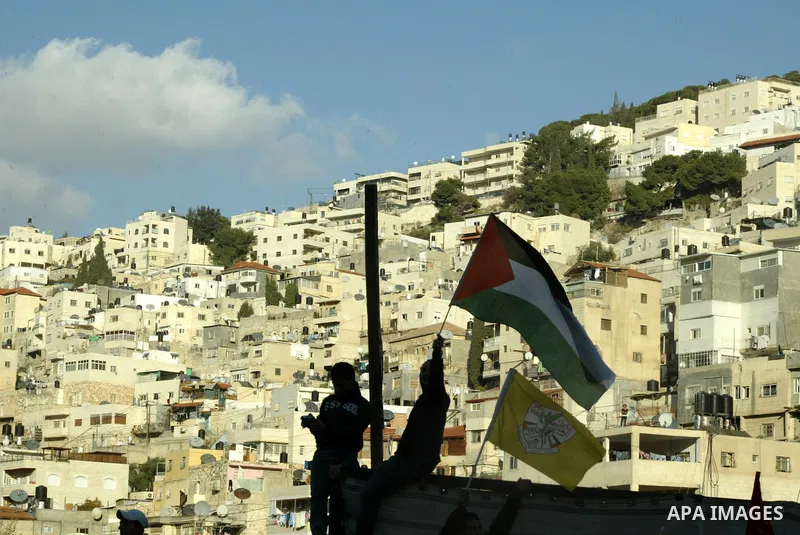 The Palestinian flag is held up as Israeli, Palestinian and foreign activists hold a demonstration in the Arab east Jerusalem neighbourhood of Silwan against Jewish settlement activity in the Palestinian districts of the...