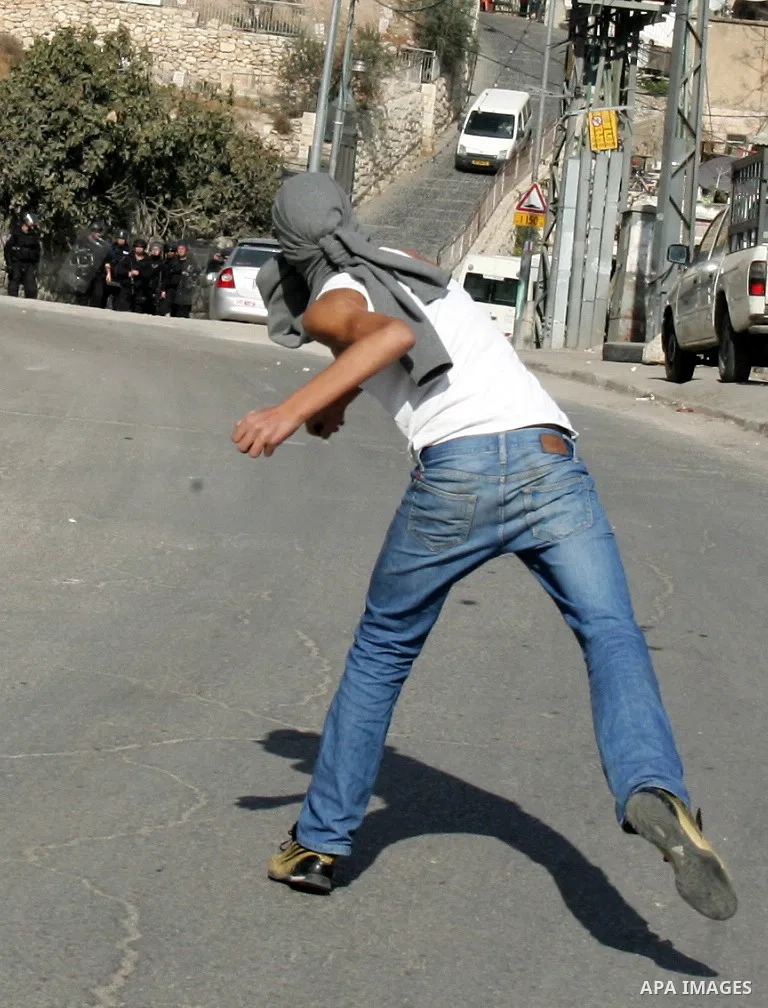 Palestinian youths throw stones towards Israeli soldiers during clashes in the Arab east Jerusalem neighbourhood of Silwan against Jewish settlement activity in the Palestinian districts of the holy city on December 24,...