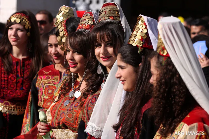 Palestinians watch scouts as they play the bagpipes during Christmas celebrations outside the Church of the Nativity, the site revered as the birthplace of Jesus, in the West Bank town of Bethlehem December 24, 2010. Pho...