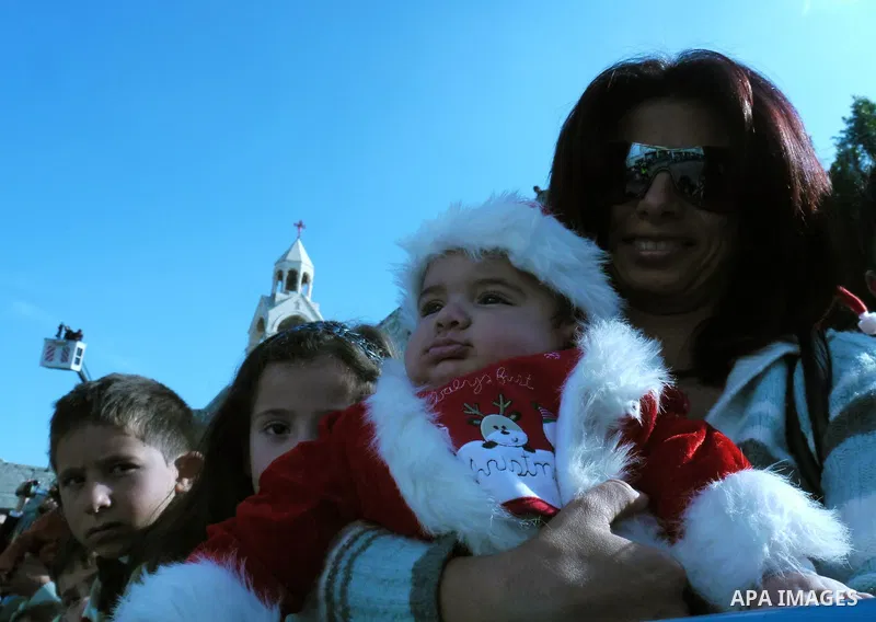 Palestinians watch scouts as they play the bagpipes during Christmas celebrations outside the Church of the Nativity, the site revered as the birthplace of Jesus, in the West Bank town of Bethlehem December 24, 2010. Pho...