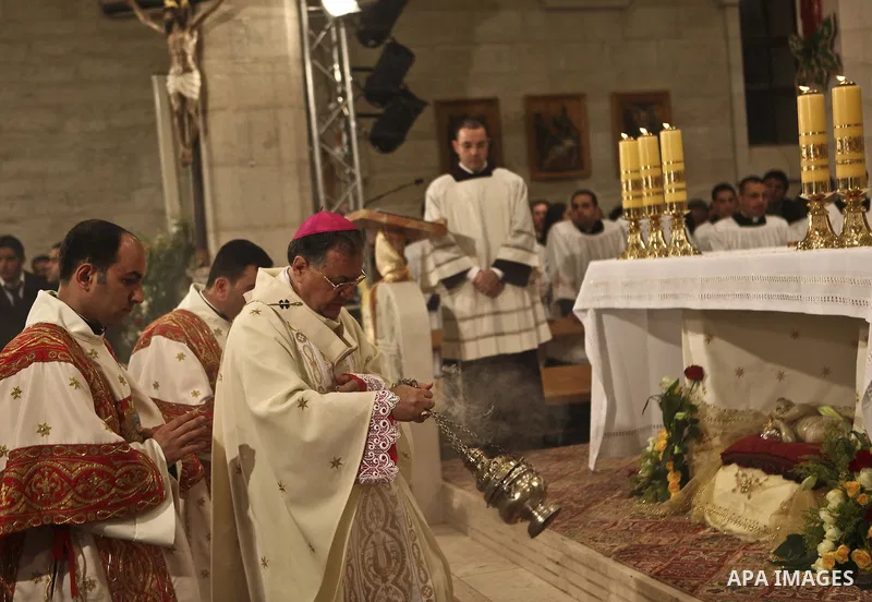 Latin Patriarch of Jerusalem Fouad Twal (R) leads Christmas midnight mass at the Church of the Nativity in the West Bank town of Bethlehem early Dec. 25, 2010. Photo by Fadi Arouri \ POOL
