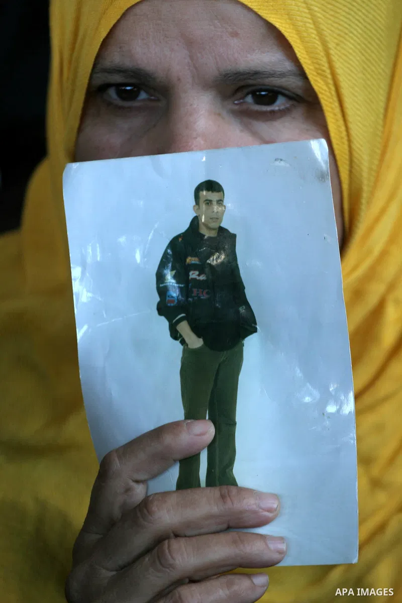 A Palestinian woman holds a picture of her prisoned relative in Israeli jails as they gather in a weekly activity calling for their liberty at the Red Cross headquarters in Gaza City on December 27, 2010. About 7000 pris...