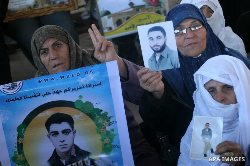 Palestinians hold pictures of their prisoned relatives in Israeli jails as they gather in a weekly activity calling for their liberty at the Red Cross headquarters in Gaza City on December 27, 2010. About 7000 prisoners...