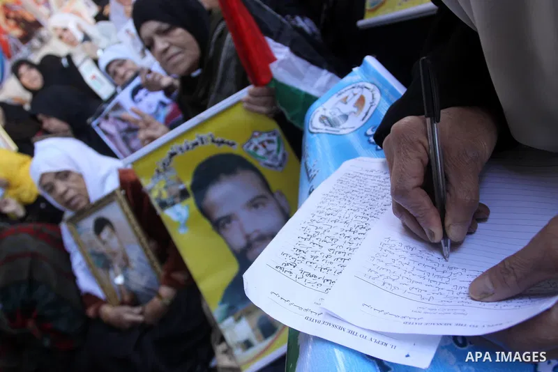 Palestinians hold pictures of their prisoned relatives in Israeli jails as they gather in a weekly activity calling for their liberty at the Red Cross headquarters in Gaza City on December 27, 2010. About 7000 prisoners...