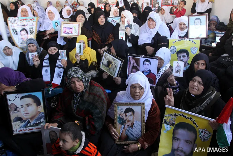 Palestinians hold pictures of their prisoned relatives in Israeli jails as they gather in a weekly activity calling for their liberty at the Red Cross headquarters in Gaza City on December 27, 2010. About 7000 prisoners...