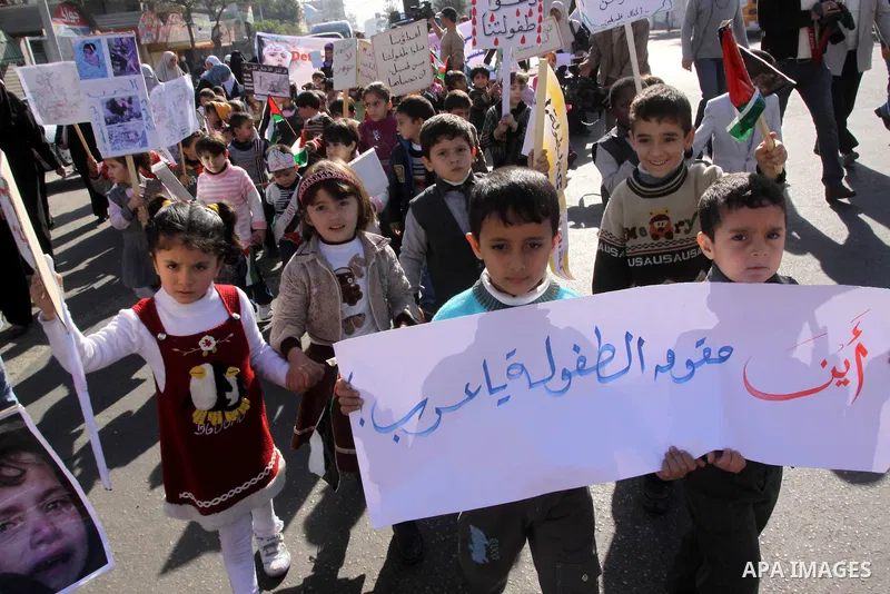 Palestinian children protest during a demonstration marking the 2nd anniversary of the Israel-Gaza war, in Gaza City on Monday, Dec. 27, 2010. Israel's volatile front with Gaza has been relatively quiet since the overwhe...